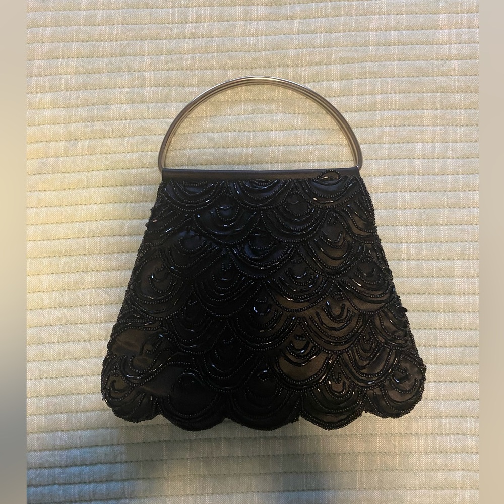 Small black beaded evening purse with silver handles.  Excellent condition.